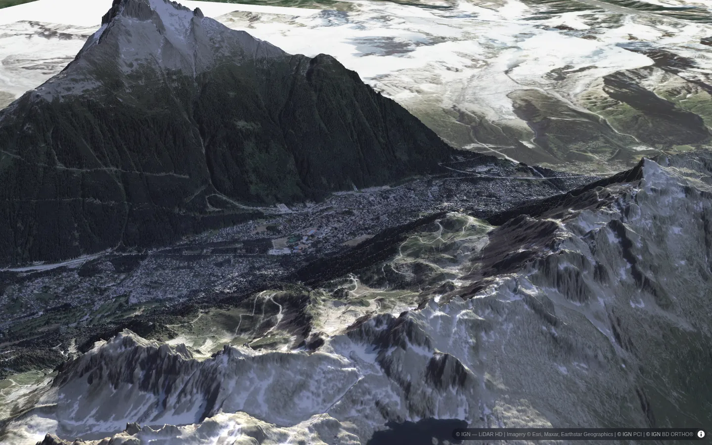 Chamonix valley in midwinter, the town in shadow below sunlit peaks